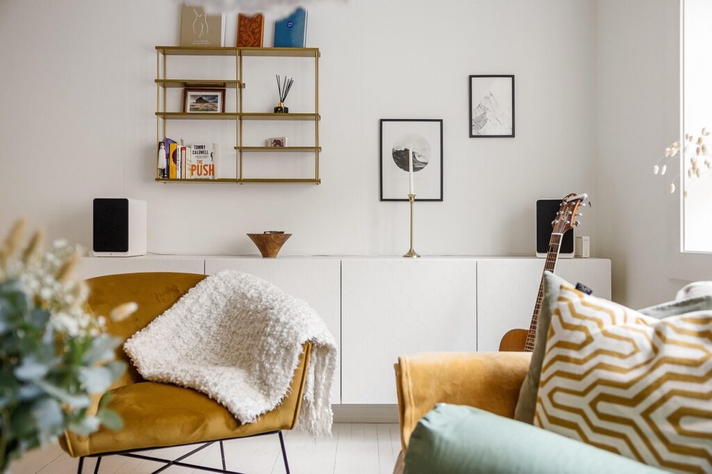 living room, sofa, chair, pillows, blanket, guitar, cabinet, console, shelves, decors, artworks, speakers, books, chair, shelves, shelves, shelves, shelves, shelves